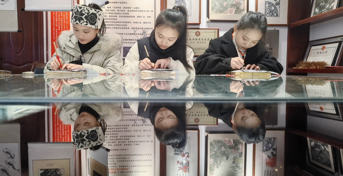 1月23日，在湖南省湘西土家族苗族自治州瀘溪縣浦市古鎮的踏虎鑿花大師工作室，三名女孩子在進行創作。
