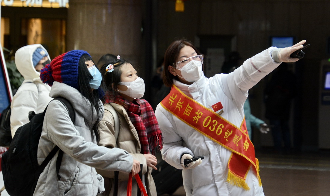 1月28日，北京西站愛心服務隊的隊員指導旅客乘車出行。