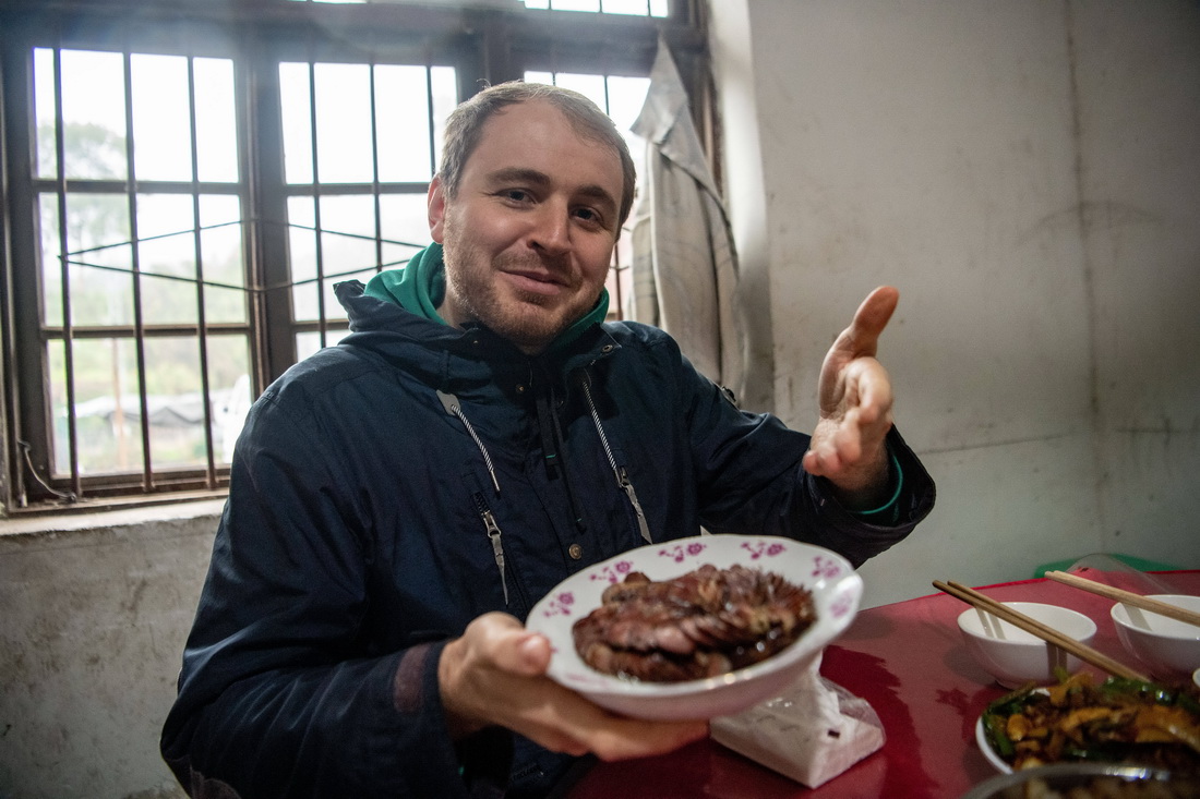 在何埂鎮柏林村，馬丁在展示當地百姓腌制的香腸（1月27日攝）。