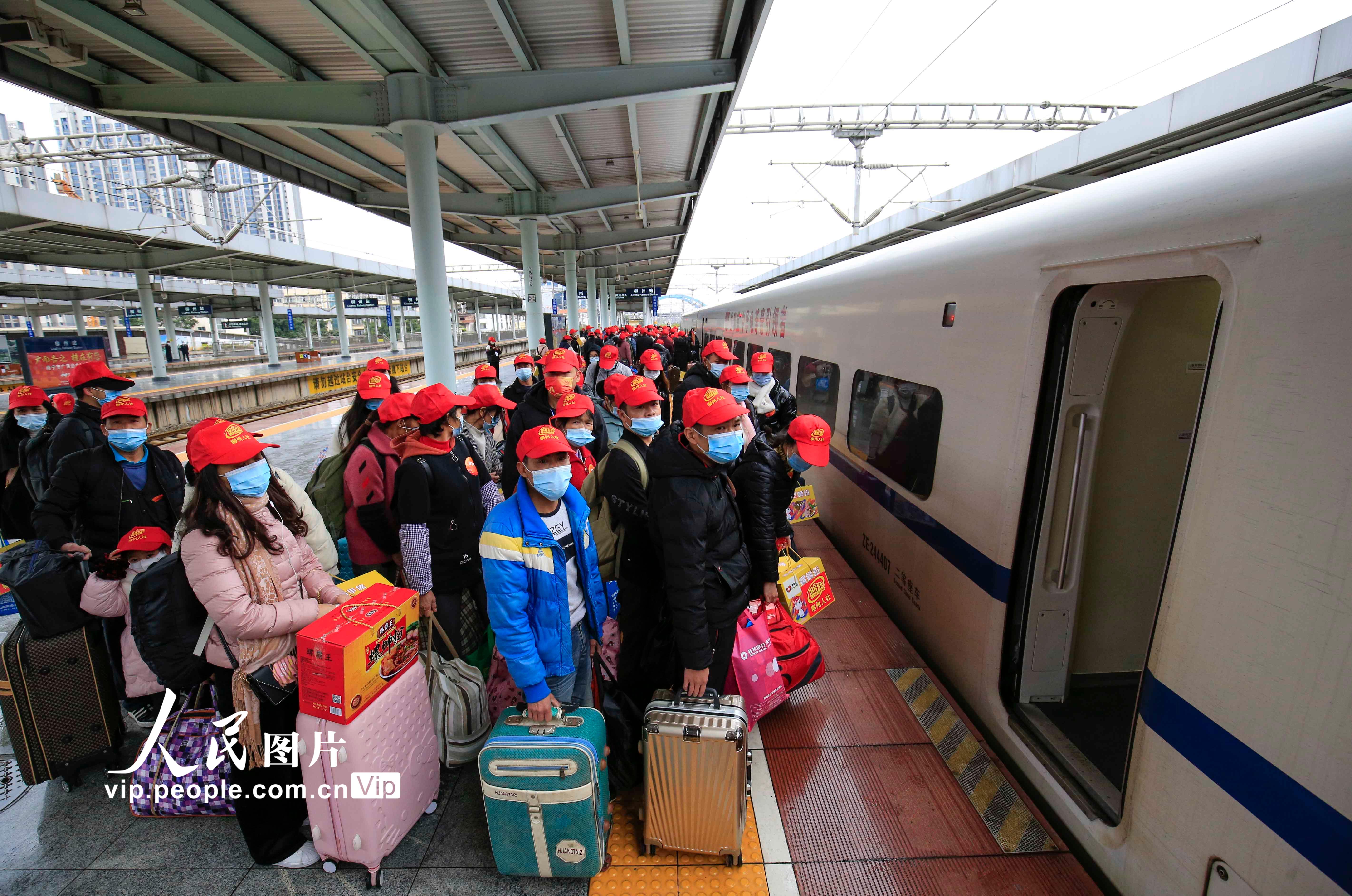 2月11日，在柳州火车站，务工人员正在排队等待上车。