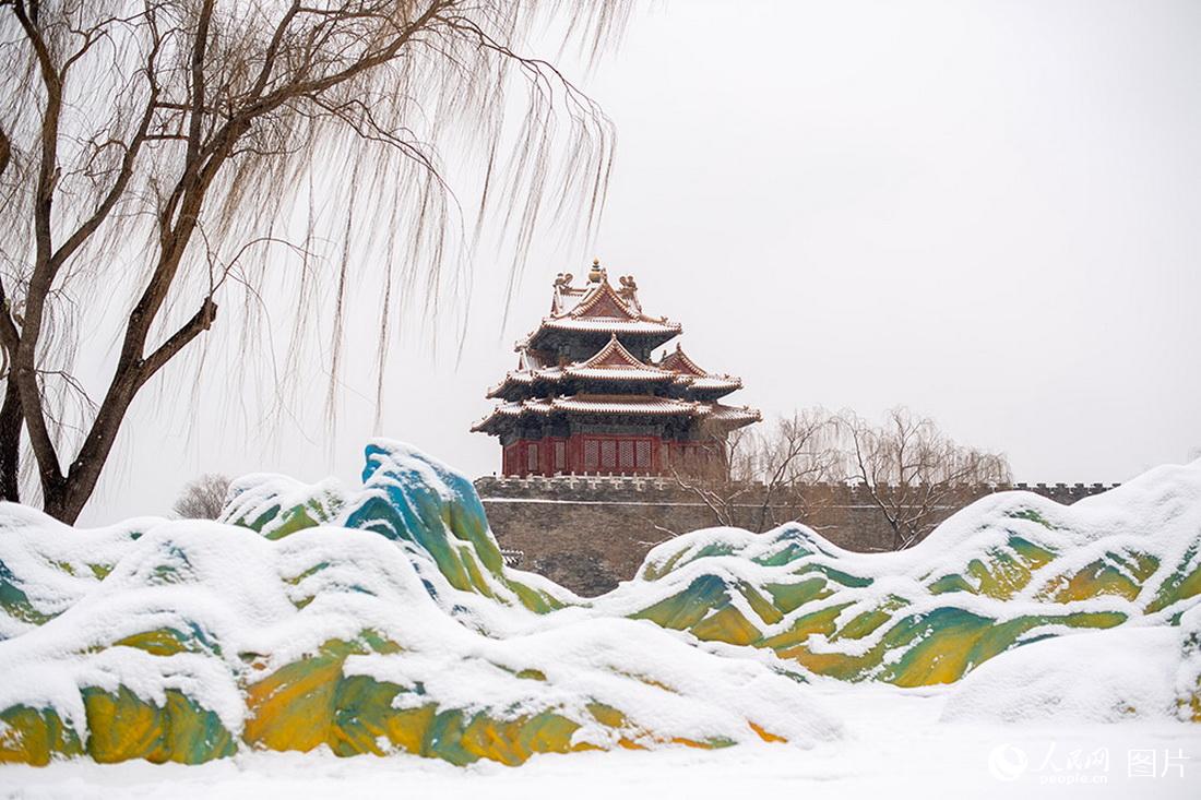 2月13日，雪中的故宫角楼与“千里江山图”景观雕塑相映成趣。人民网记者翁奇羽摄