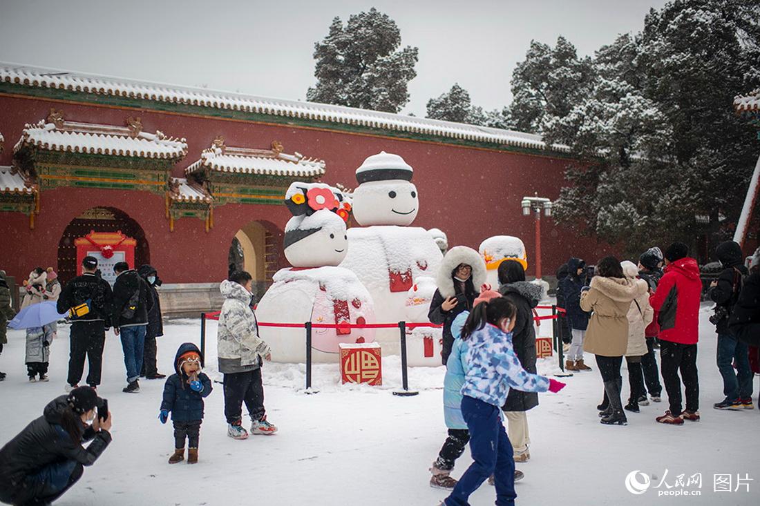 2月13日，在北京景山公园，游客尽享降雪带来的欢乐。人民网记者翁奇羽摄