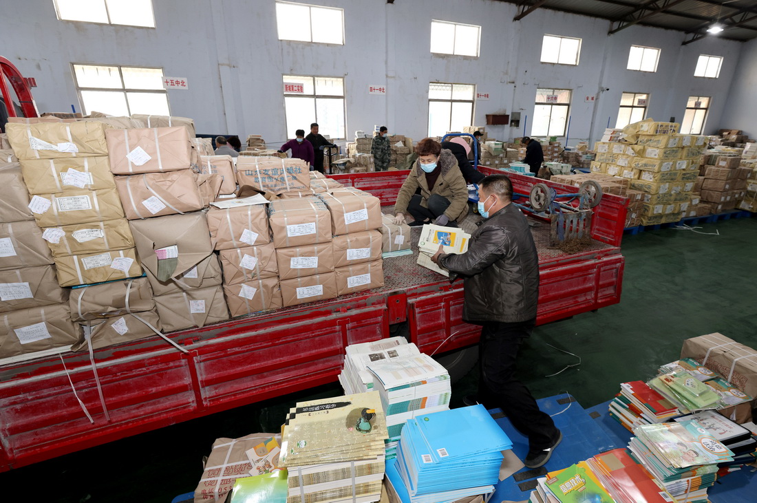 2月12日，在山东省枣庄市新华书店教材发行中心，工作人员在装运教材。新华社发（孙中�瓷悖�