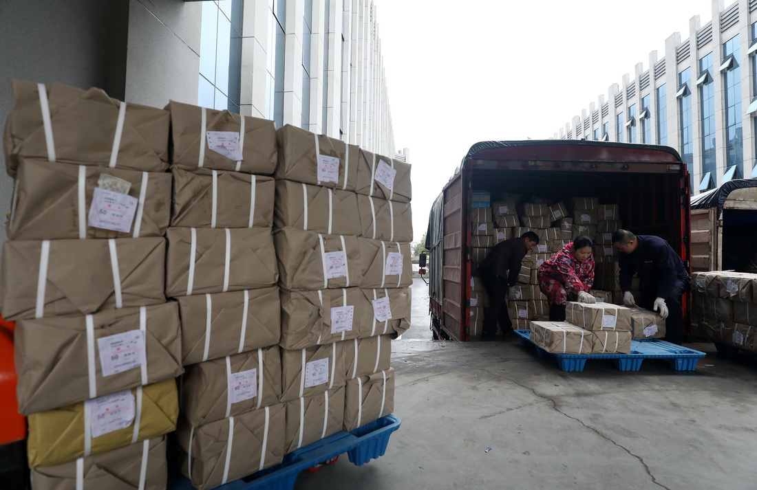 2月13日，在湖南省資興市新華書店倉庫，工作人員將教材裝車。新華社發（李科攝）