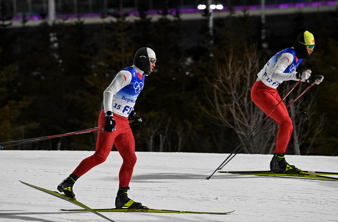 北京2022年冬奧會越野滑雪女子個人短距離半決賽開賽前，吐爾鬆江·布爾力克（左）和隊友在國家越野滑雪中心的賽道上試滑（2月8日攝）。