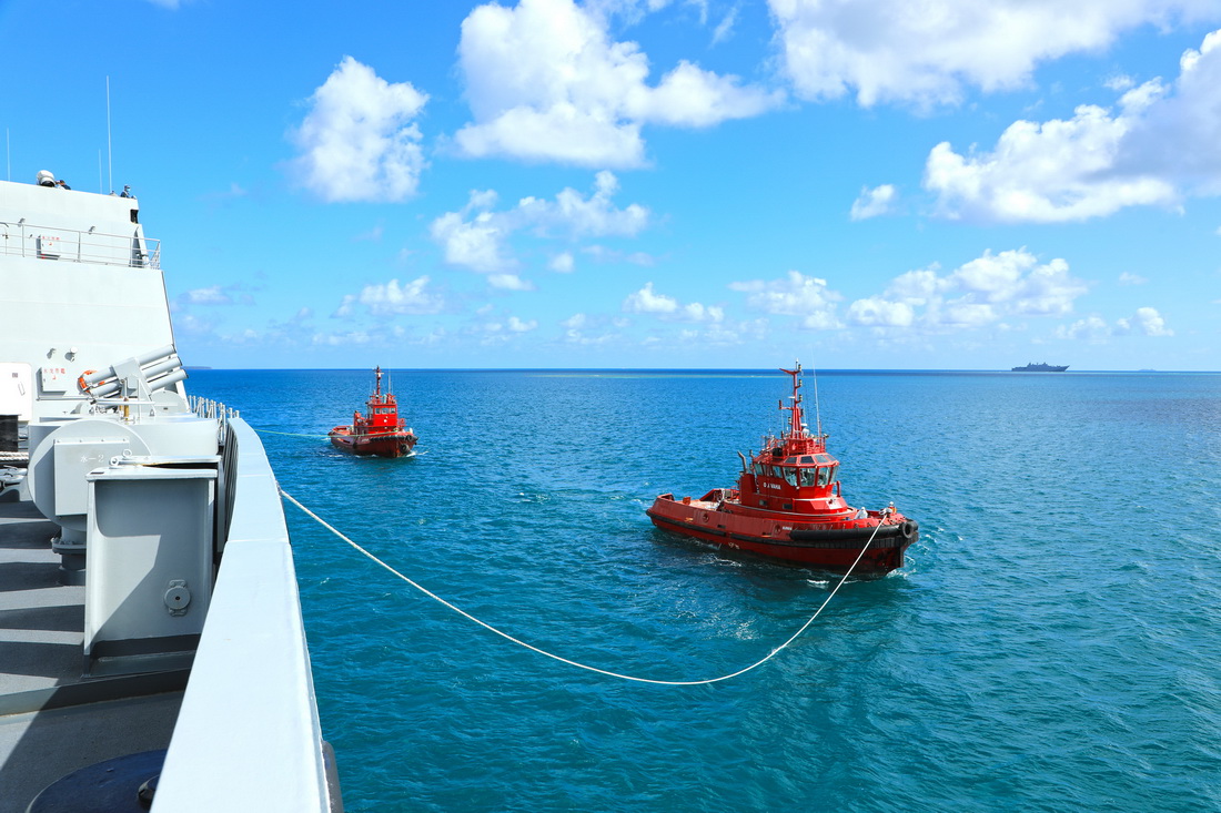 2月15日，赴湯加執行運送救災物資任務的中國海軍艦艇編隊抵達湯加努庫阿洛法港，湯方拖船協助我方軍艦靠泊。新華社發（薛成清 攝）