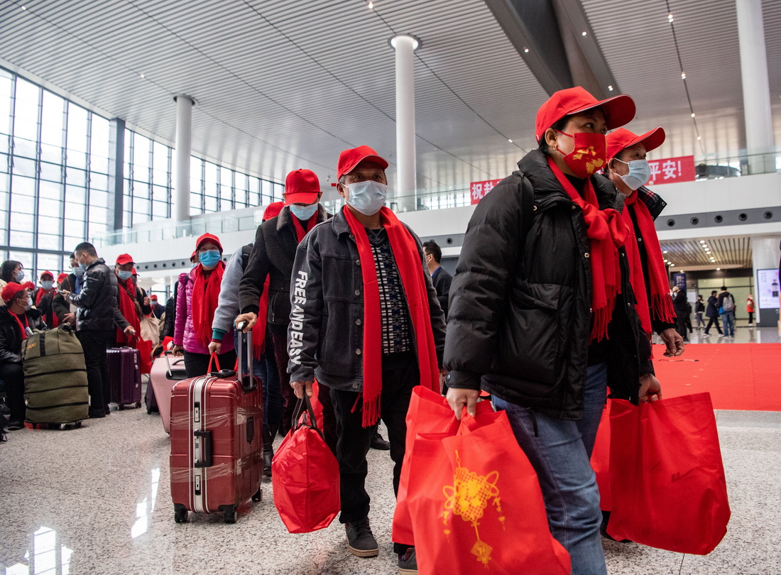 2月16日，返崗務工人員在重慶西站候車廳排隊前往檢票口。