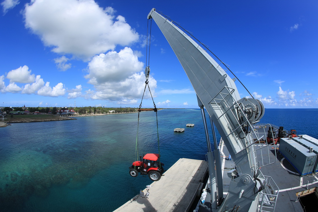 赴汤加执行运送救灾物资任务的中国海军舰艇编队在努库阿洛法港卸载拖拉机（2月19日摄）。新华社发（薛成清 摄）