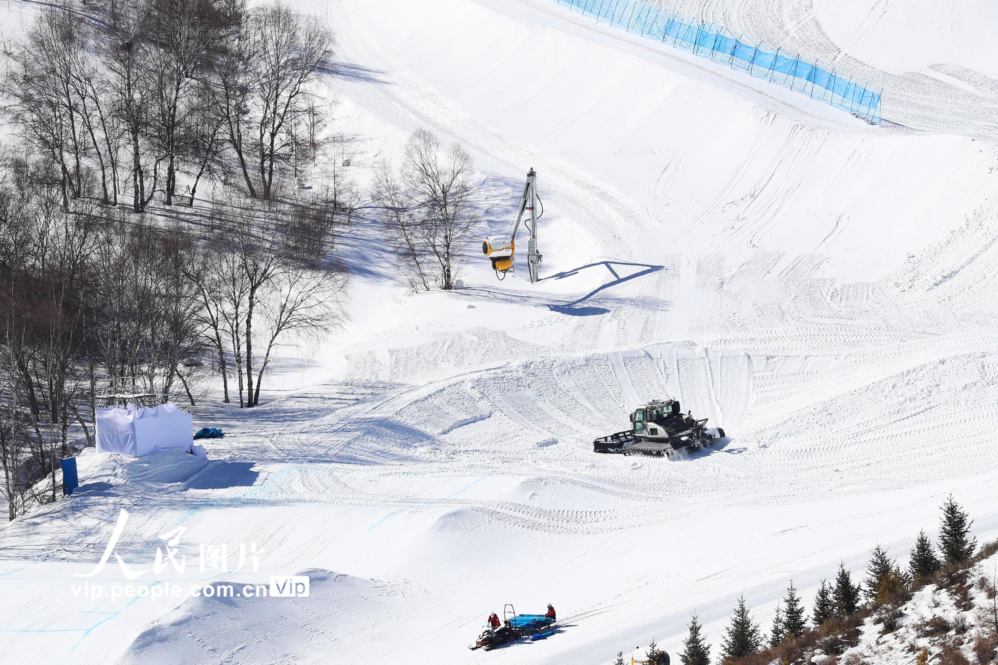 2月23日，工作人員、機械設備在河北省張家口賽區雲頂滑雪公園進行賽道二次塑型作業。