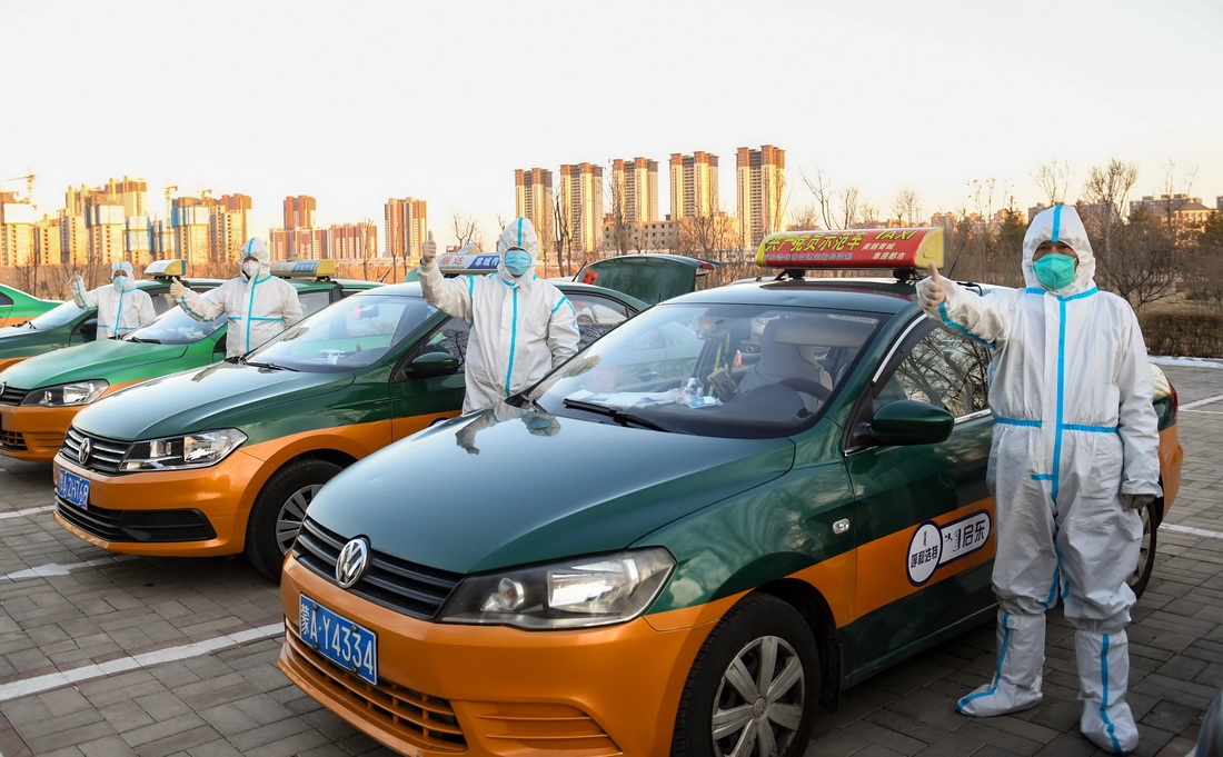 2月22日，趙永紅（右一）和運送核酸檢測樣本的出租車司機合影。新華社記者 彭源 攝