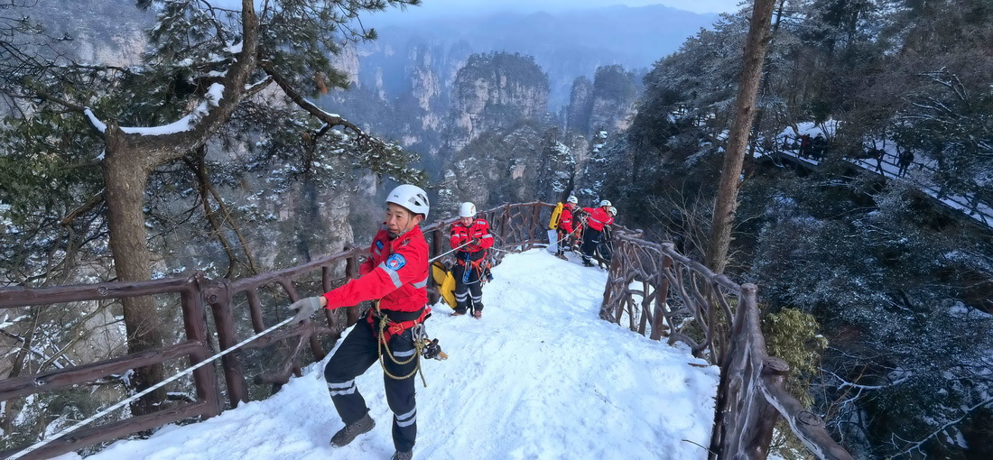 2月23日，張家界市武陵源山地應急救援隊隊員在黃石寨利用安全繩進行團體協同配合訓練（手機照片）。