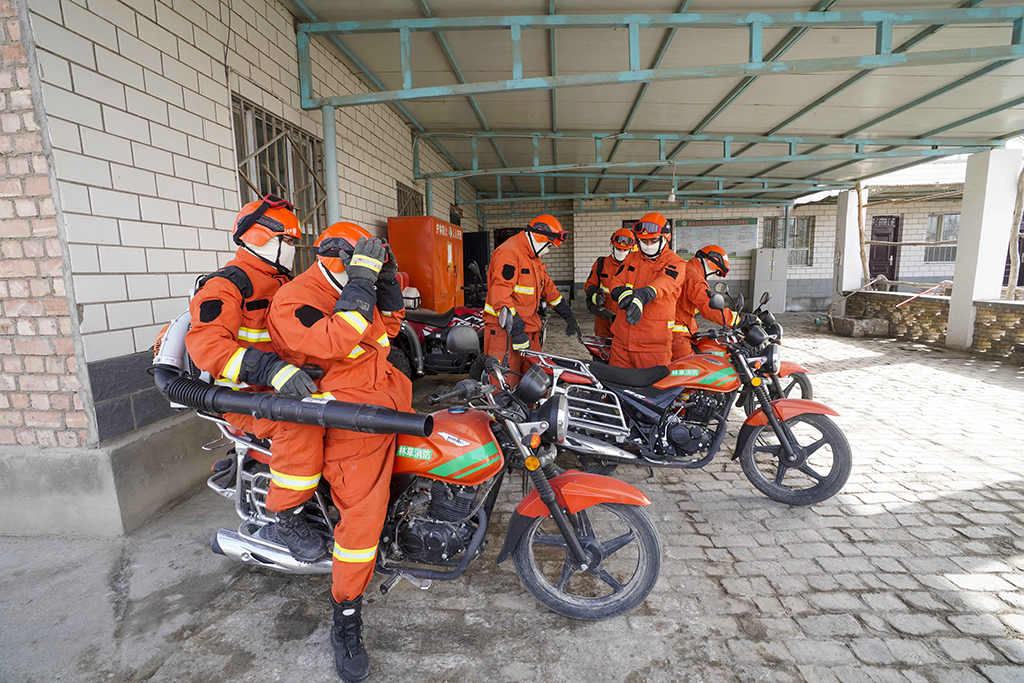 尉犁縣森林草原應急分隊成員准備騎摩托車前往一處胡楊林展開訓練（2月22日攝）。新華社記者 趙戈 攝