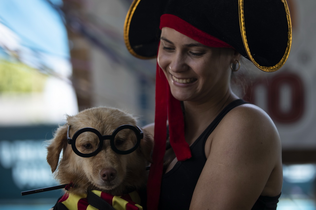 2月27日，一名女子帶著寵物犬在巴西裡約熱內盧參加“狗狗狂歡節”活動。