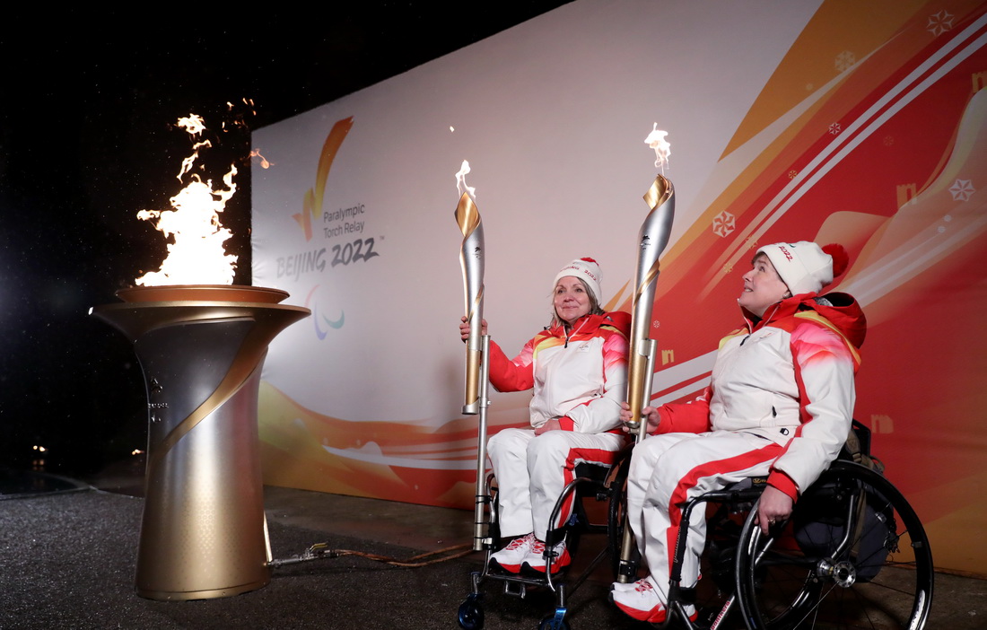 2月28日，火炬手、轮椅冰壶运动员尼尔森（右）和马隆在火种采集仪式上。