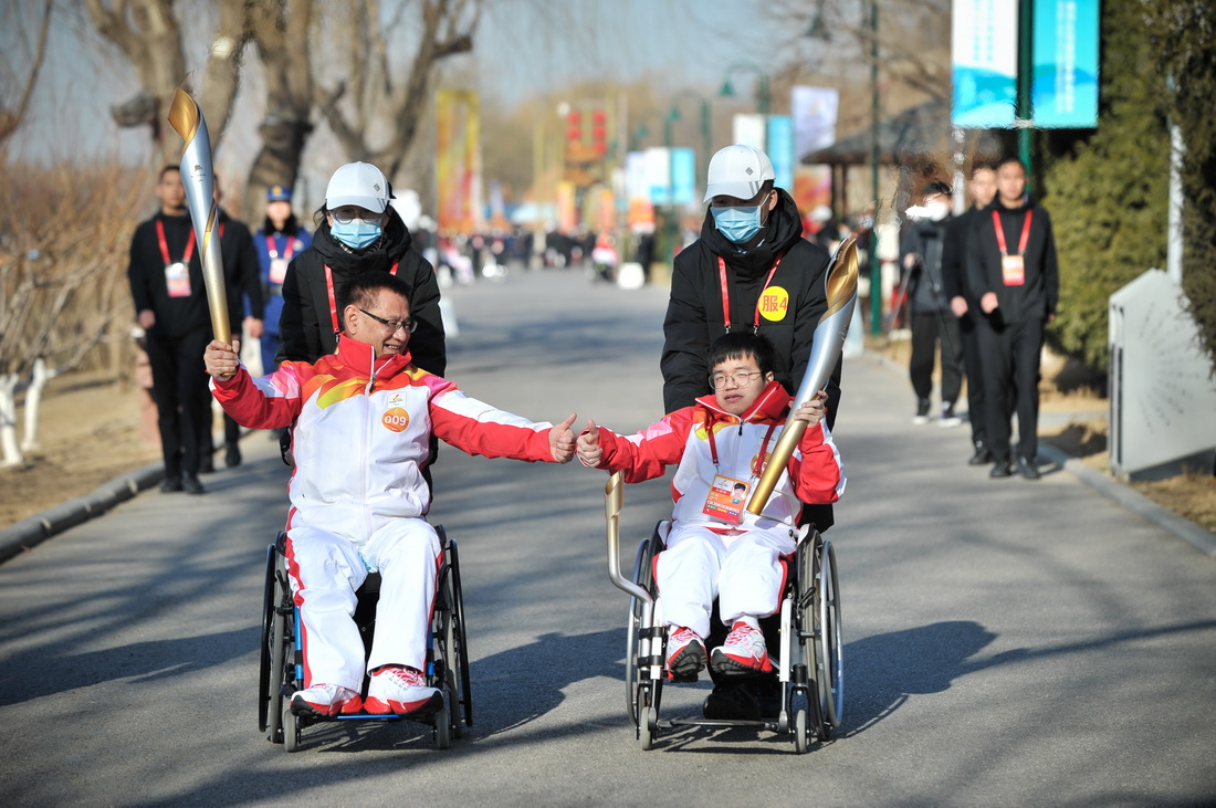 3月2日，火炬手王俊友（前左）、劉周在城市火種火炬傳遞中。新華社記者 李任滋 攝