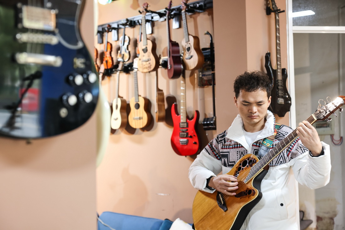 3月1日，“折耳根”樂隊吉他手楊志在琴行內排練。