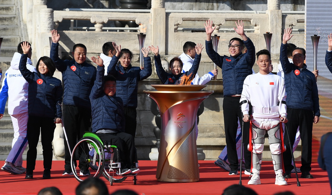 3月2日，殘疾人運動員、殘聯等各界人士代表手持採火棒登上主席台，用取自九個點位的火種共同點燃儀式火種台。新華社記者 陶希夷 攝