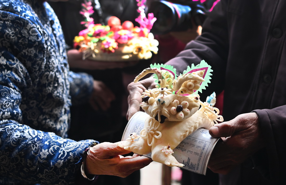 3月3日，阿壽村村民在品鑒參展的面花作品。阿壽村有9家面花制作店鋪，面花制作從家庭制作逐漸轉化為具有商品形式的店面制作。