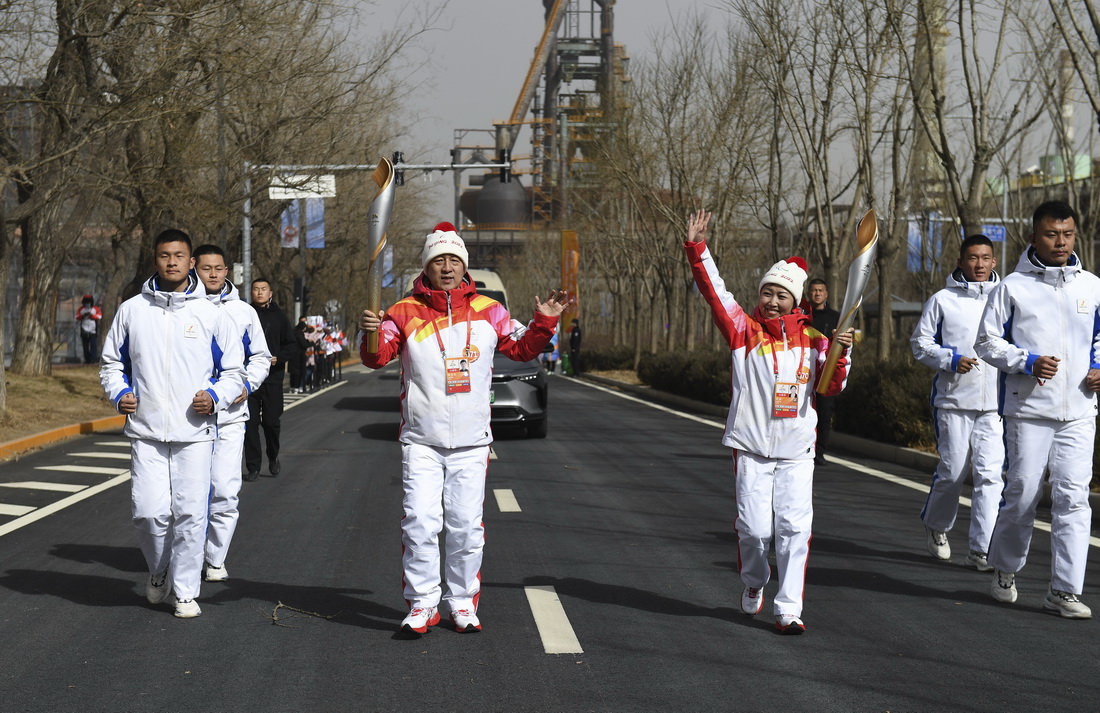 3月4日，火炬手杨华清（前排左二）和赵星在传递火炬。