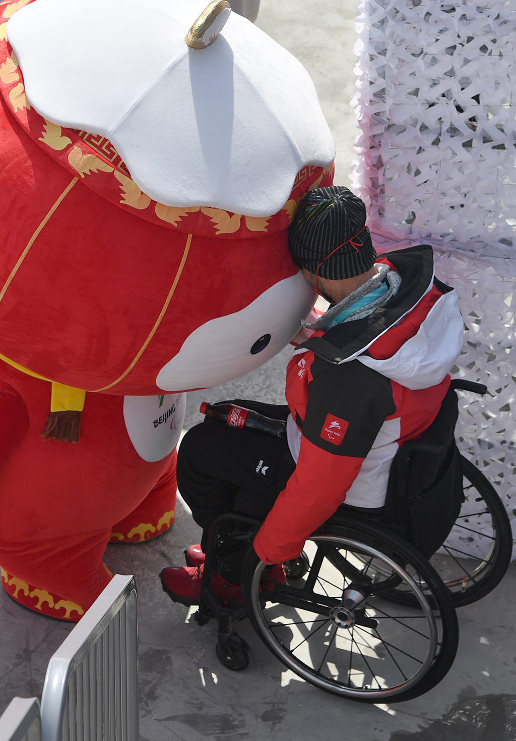在延慶國家高山滑雪中心，“雪容融”和一名運動員“碰頭”互動（3月10日攝）。新華社記者 李嘉南 攝