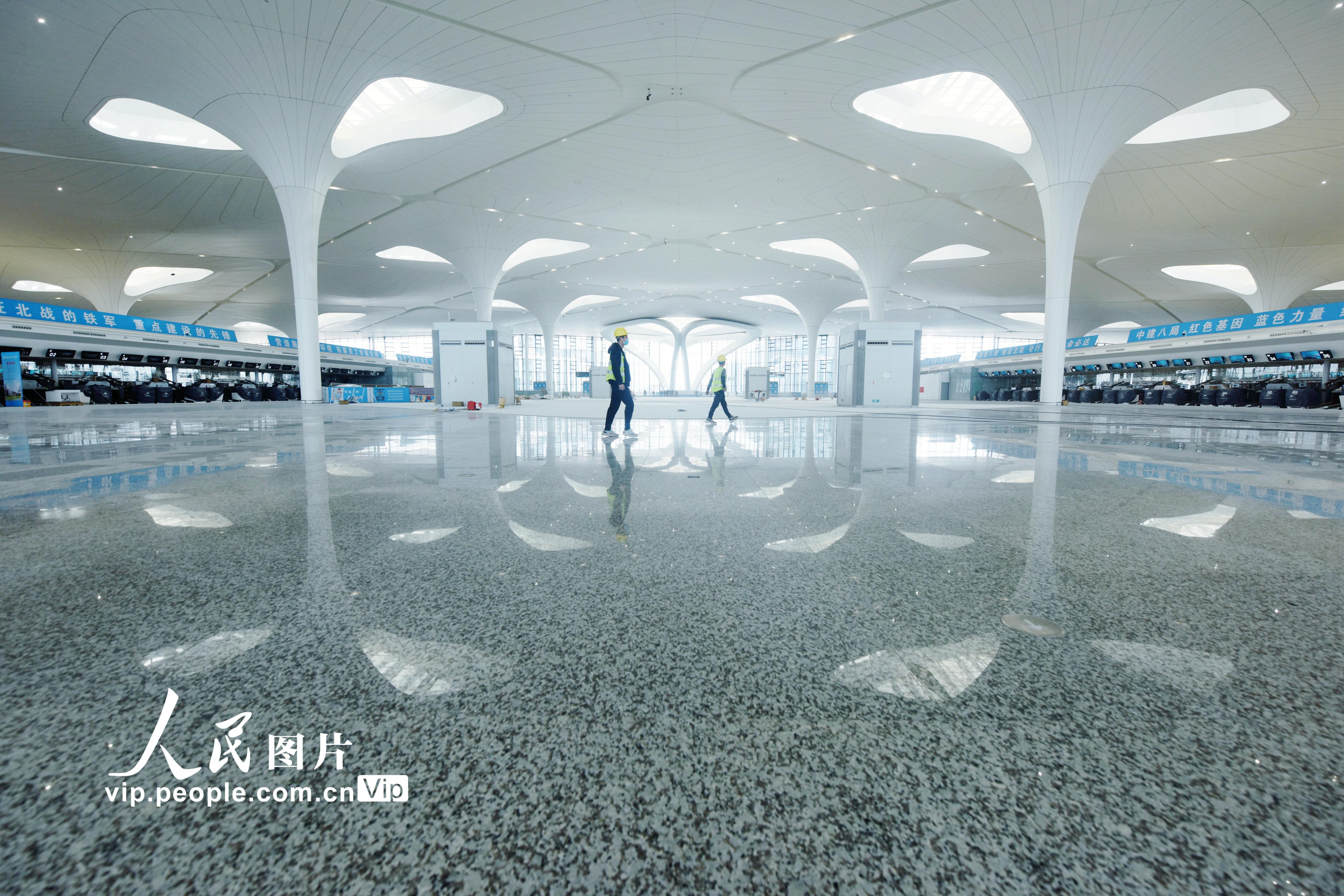 2022年3月15日，工人從杭州蕭山國際機場T4航站樓採用荷葉造型設計的出發大廳走過。