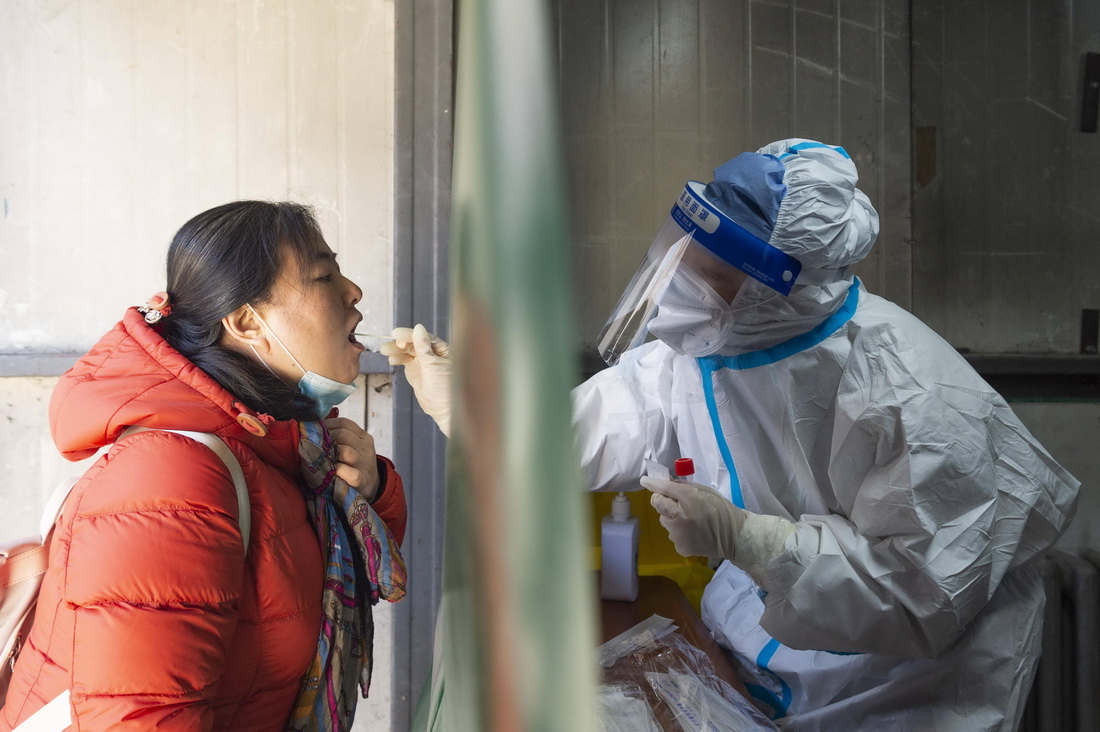 3月18日，在哈爾濱市香坊區一核酸採樣點，醫務人員進行核酸採樣。