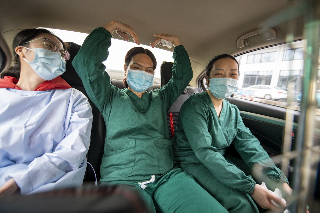3月19日早上，醫護人員完成任務后，坐在方秋丹的車上“比心”。