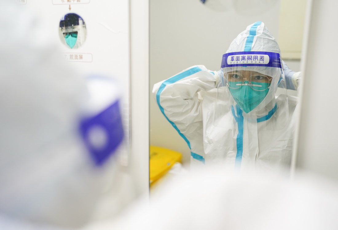 3月23日凌晨，核酸檢測實驗室的工作人員呂文航在穿戴防護面罩。