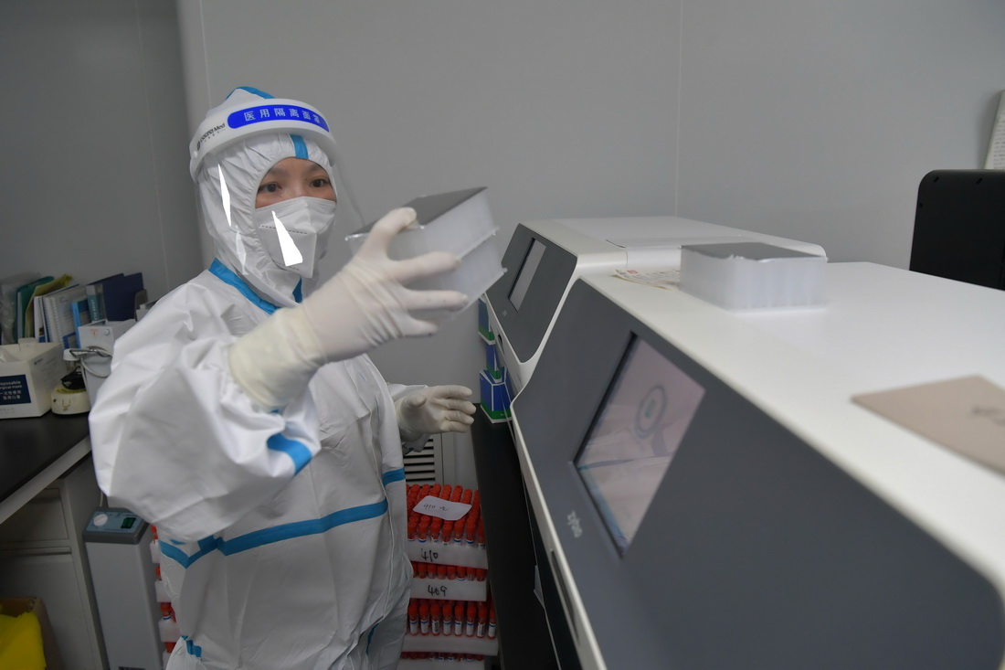 在南昌大學二附院醫學檢驗中心核酸檢測實驗室，核酸檢測員在使用設備對標本提取核酸（3月23日攝）。