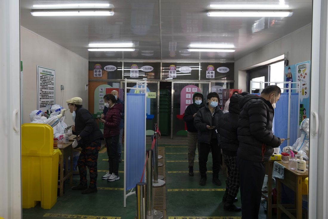 3月25日，在哈爾濱市香坊區大慶副路上的一處免費核酸採樣點，市民在排隊登記信息、接受核酸採樣。新華社記者 張濤 攝