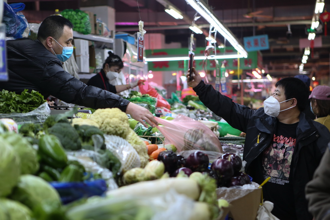 3月25日，在沈阳市凤祥综合市场，一名市民买菜后扫码付款。新华社记者 王乙杰 摄