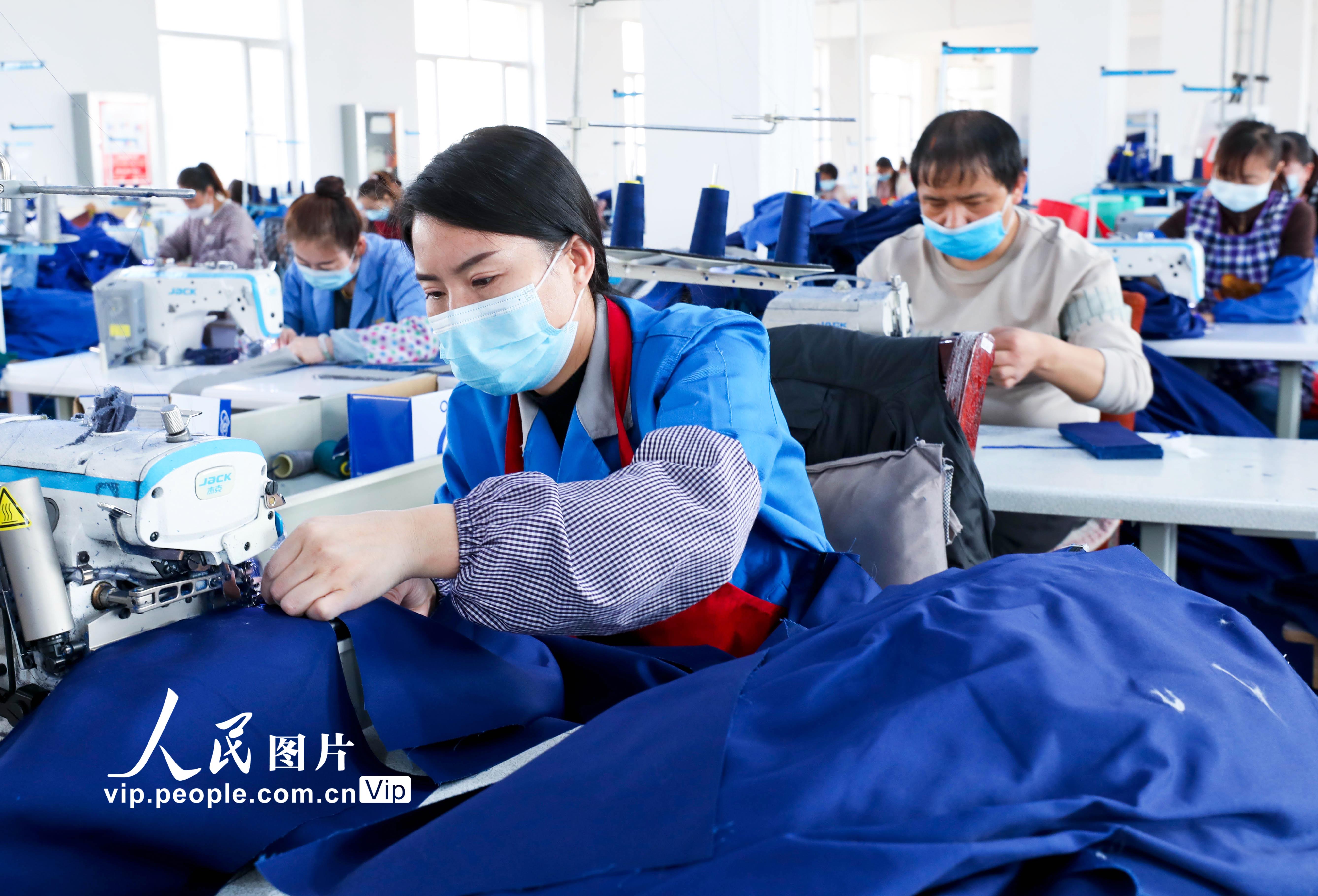 2022年3月24日，甘肃省张掖市山丹县海兰达服饰乡村就业工厂内，100多名妇女正在紧张有序的赶制加工江苏、浙江客户定制的近万套工作服。