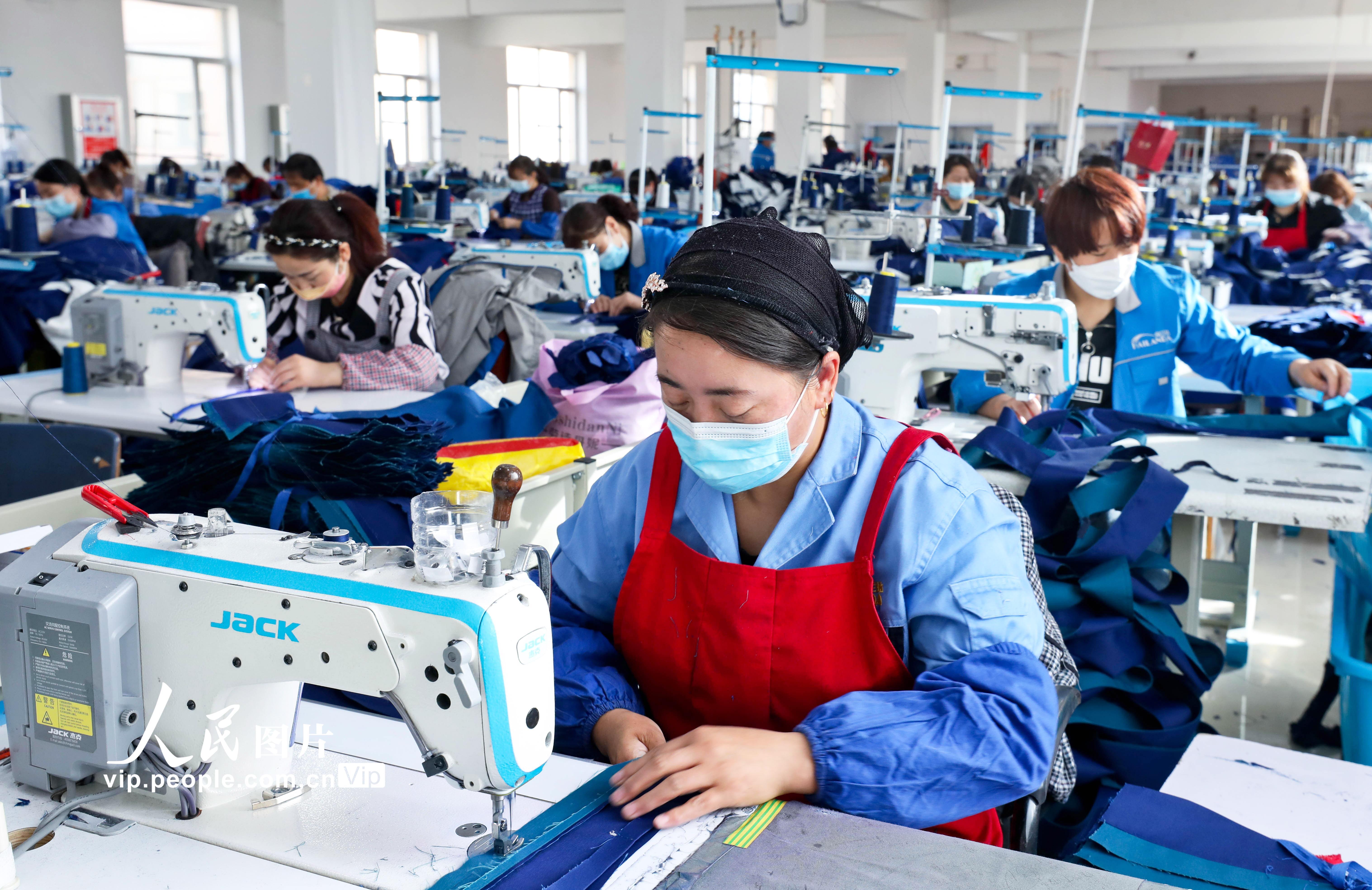 2022年3月24日，甘肅省張掖市山丹縣海蘭達服飾鄉村就業工廠內，100多名婦女正在緊張有序的趕制加工江蘇、浙江客戶定制的近萬套工作服。