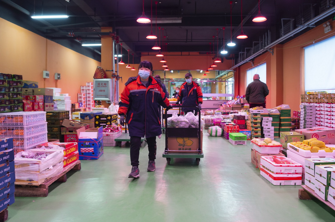 3月29日，在哈爾濱市鬆北區潤恆國際食品交易中心蔬菜區，工作人員在搬運貨品。新華社記者 謝劍飛 攝