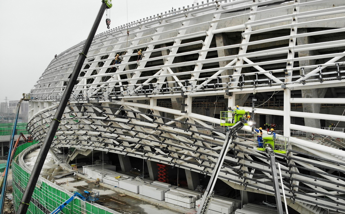 在青島青春足球場項目建設現場，工人在搭建幕牆龍骨（3月30日攝，無人機照片）。