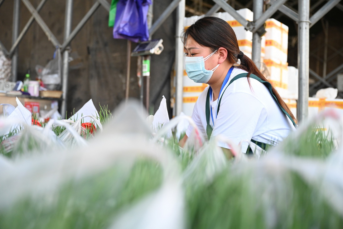 3月30日，在福建省晋江市禾恒蔬菜批发市场，批发商清点蔬菜。