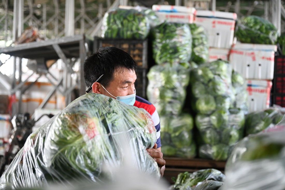 3月30日，在福建省晉江市禾恆蔬菜批發市場，商販在搬運蔬菜。