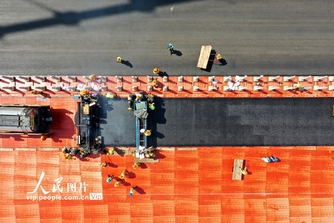 4月5日，在浙江省溫州市甌江北口大橋上層，工人們正在鋪設瀝青。