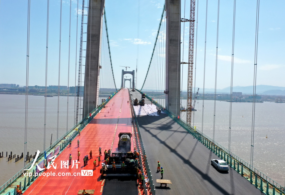 4月5日，在浙江省溫州市甌江北口大橋上層，工人們正在鋪設瀝青。