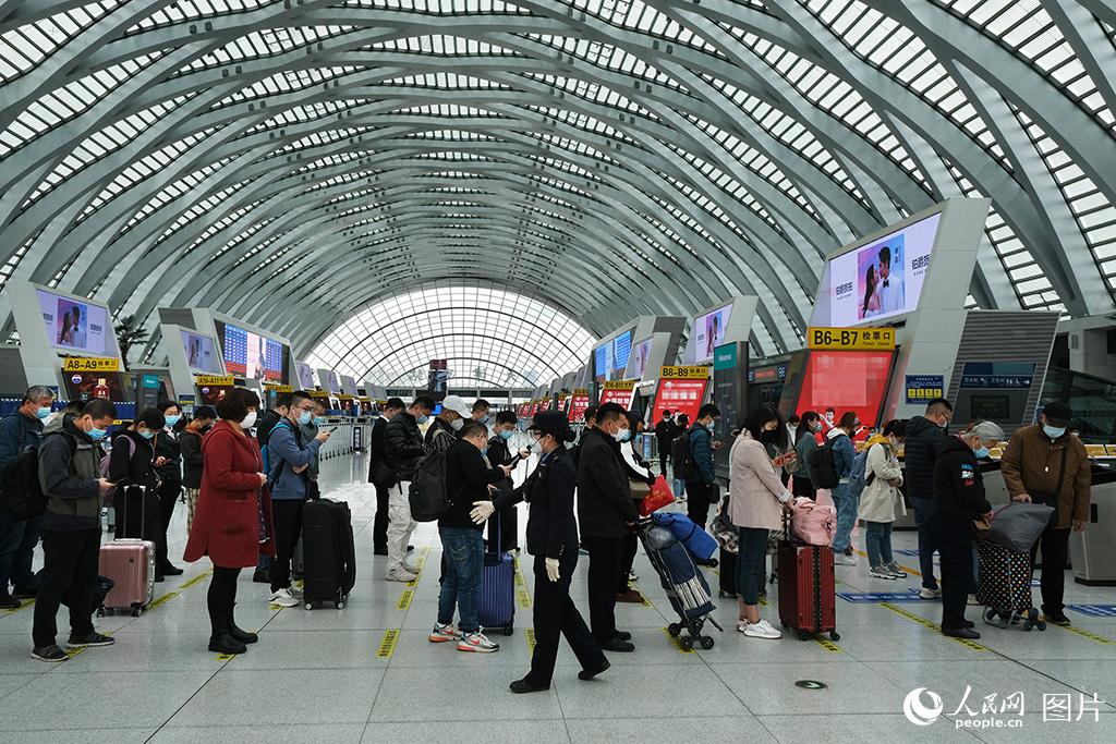 4月6日，鐵路天津西站工作人員引導旅客排隊按一米線距離驗票乘車。
