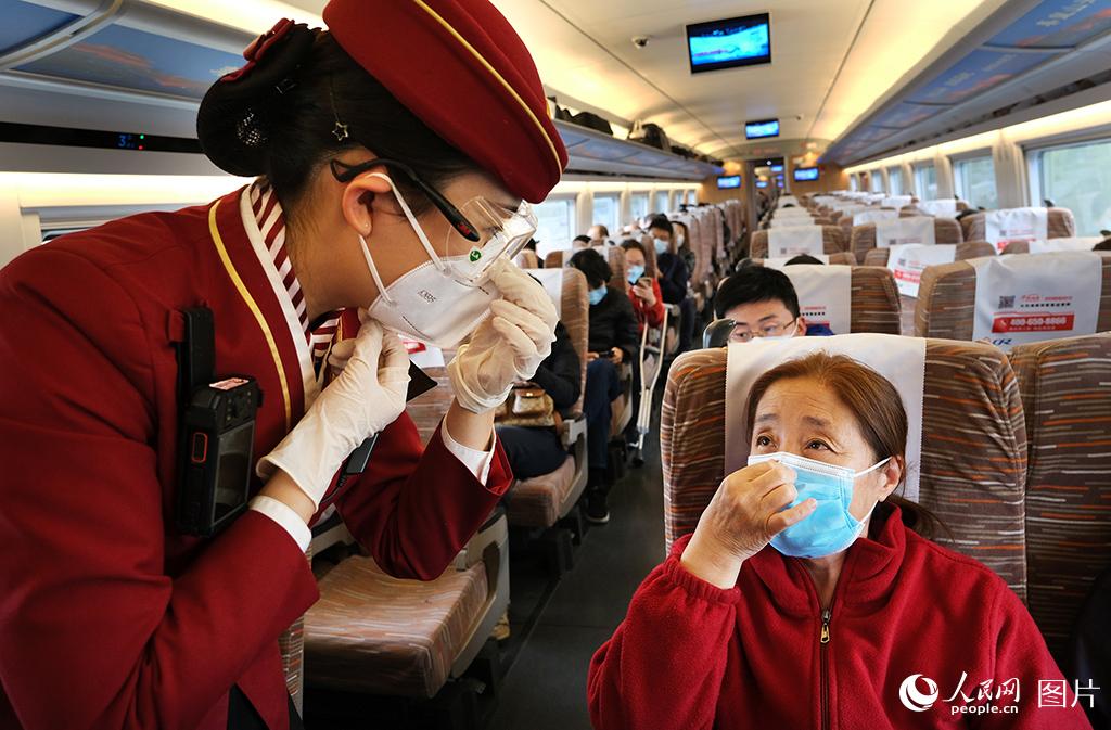 4月6日，鐵路天津客運段京津城際列車乘務人員指導乘車旅客如何正確使用佩戴口罩。