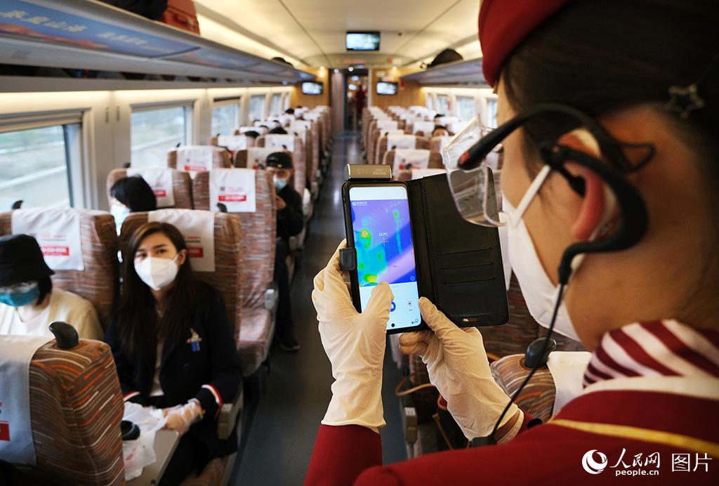 4月6日，鐵路天津客運段京津城際列車乘務人員對旅客進行體溫檢測。