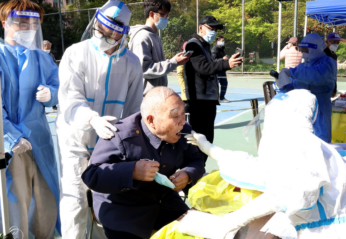 4月4日，87岁的虞祖荣老人在志愿者的协助下进行核酸检测采样。