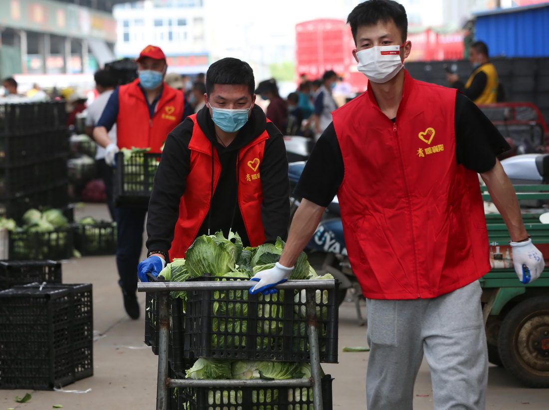 4月9日，在湖北省襄陽市竹葉山農產品交易中心，志願者在分揀蔬菜。