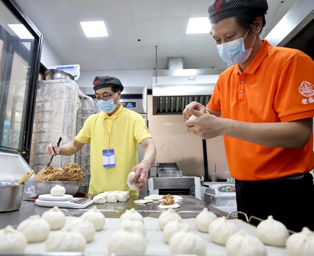 4月10日，上海老盛昌徐江區梅隴路店員工黃慶（右）、任海在恢復營業的店內忙碌。