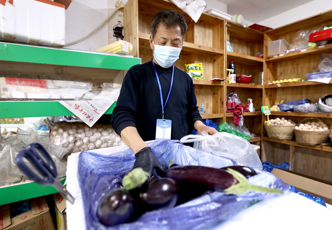 4月10日，上海超杰綜合生鮮超市員工徐啟銀在恢復營業的店內為網上訂單分裝蔬菜。