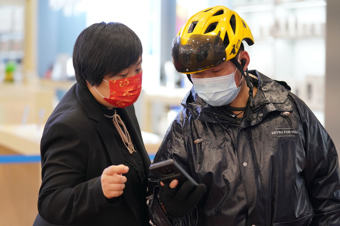 4月11日，在哈爾濱市香坊區一百貨商場門口，工作人員在檢查入店人員健康碼。新華社記者 王建威 攝