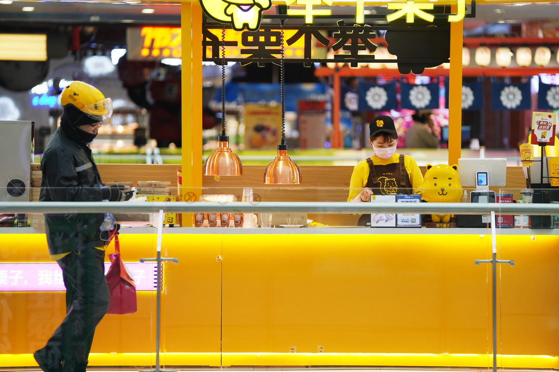 4月11日，在哈爾濱市香坊區一商業廣場內，一名外賣送餐員准備離開餐飲區送餐。新華社記者 王建威 攝