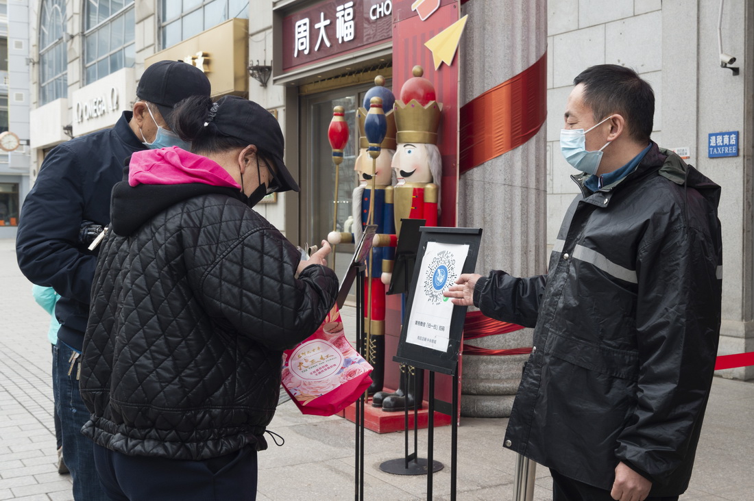 4月11日，在哈爾濱市中央大街一商場入口，工作人員引導進入人員掃碼。新華社記者 謝劍飛 攝