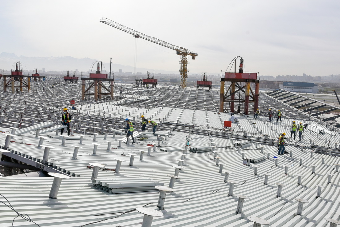 4月13日，在烏魯木齊機場改擴建項目施工現場，施工人員進行航站樓屋面頂板安裝工作。